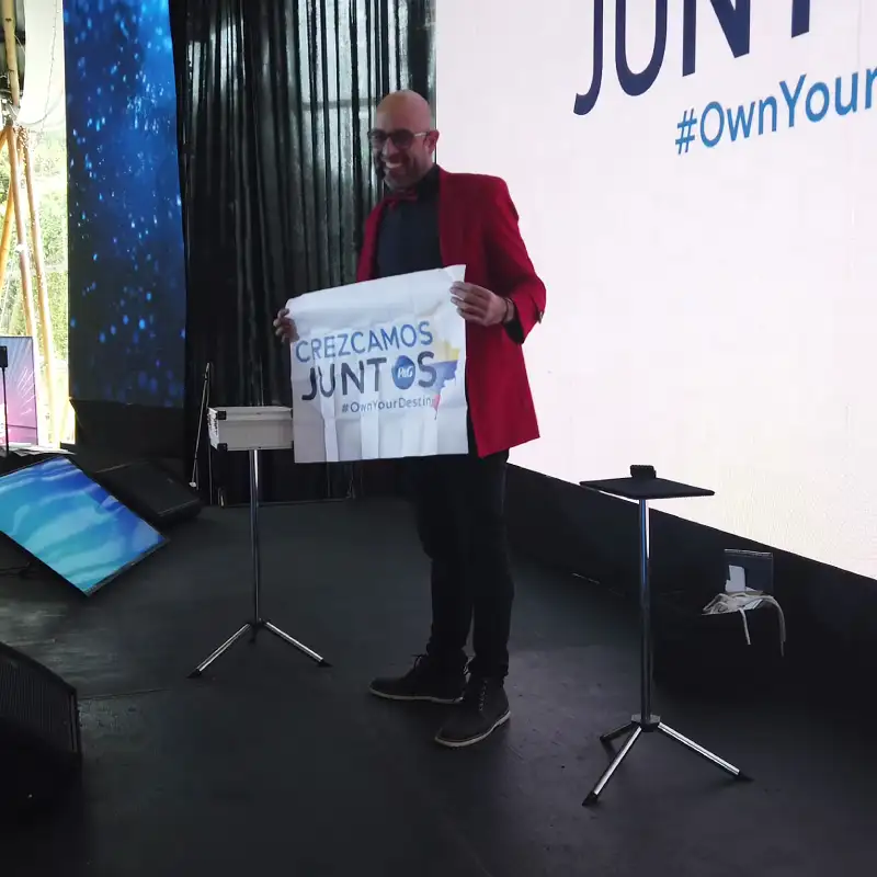 Facilitador utilizando metáforas visuales con el mensaje Crezcamos Juntos en una actividad de integración para empresas.